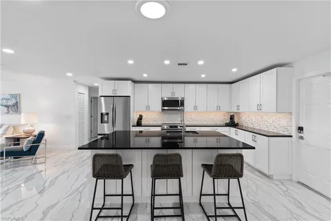 a kitchen with stainless steel appliances kitchen island granite countertop a sink and cabinets