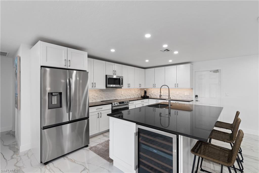 2500 Kings Lake Boulevard Naples, FL 34112 - Photo 8 of 31 a kitchen with stainless steel appliances granite countertop a refrigerator a stove a sink and a refrigerator