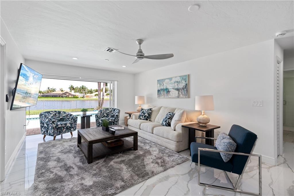 2500 Kings Lake Boulevard Naples, FL 34112 - Photo 10 of 31 a living room with furniture and a large window with garden view
