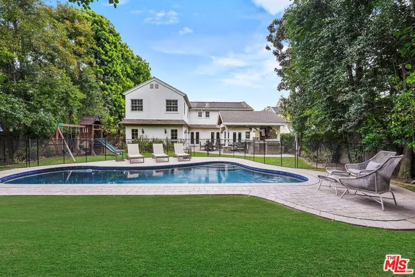 a view of a house with pool and chairs