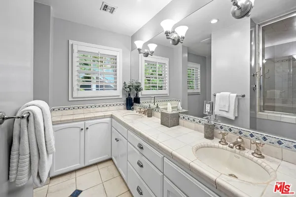 a bathroom with a granite countertop sink a large mirror and a bathtub