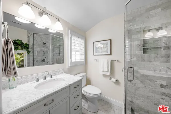 a bathroom with a granite countertop sink toilet and shower