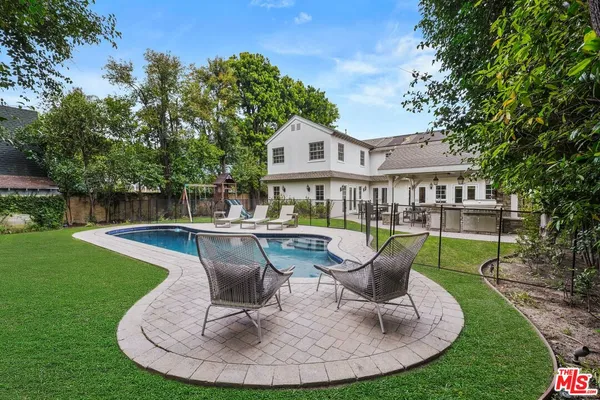 a view of a house with a yard patio and swimming pool