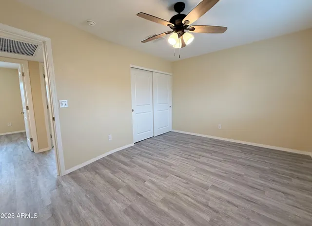 a view of a big room with wooden floor and a ceiling fan
