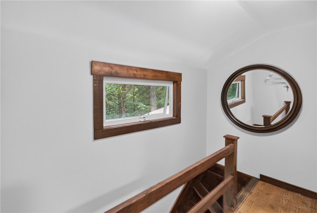 130 Maggie Rufus Lane Westminster, SC 29693 - Photo 27 of 50 Hardwood flooring extends throughout this well-lit stairwell, leading to a framed window overlooking natural surroundings.