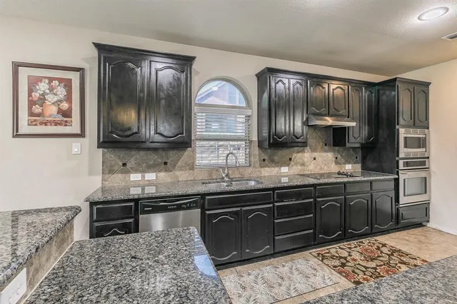 a kitchen with stainless steel appliances granite countertop a sink and cabinets