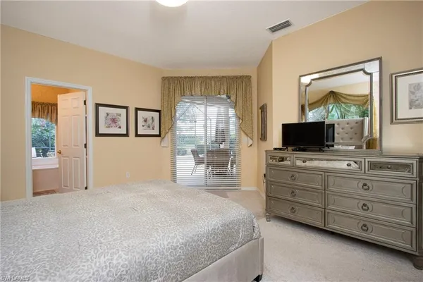 a bedroom with a large bed and a flat tv screen on a dresser