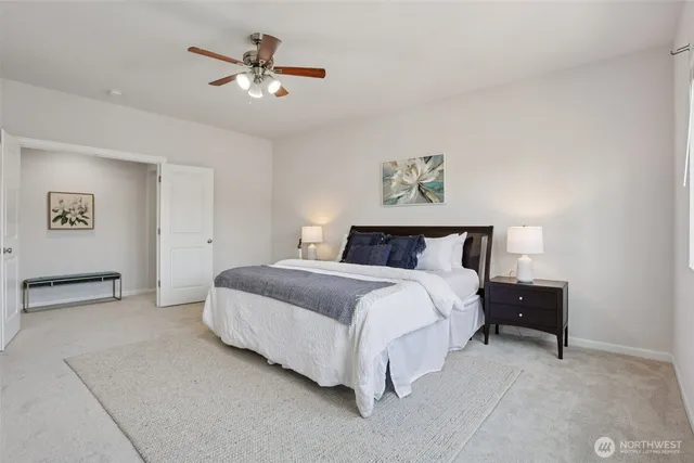 a spacious bedroom with a bed and a ceiling fan