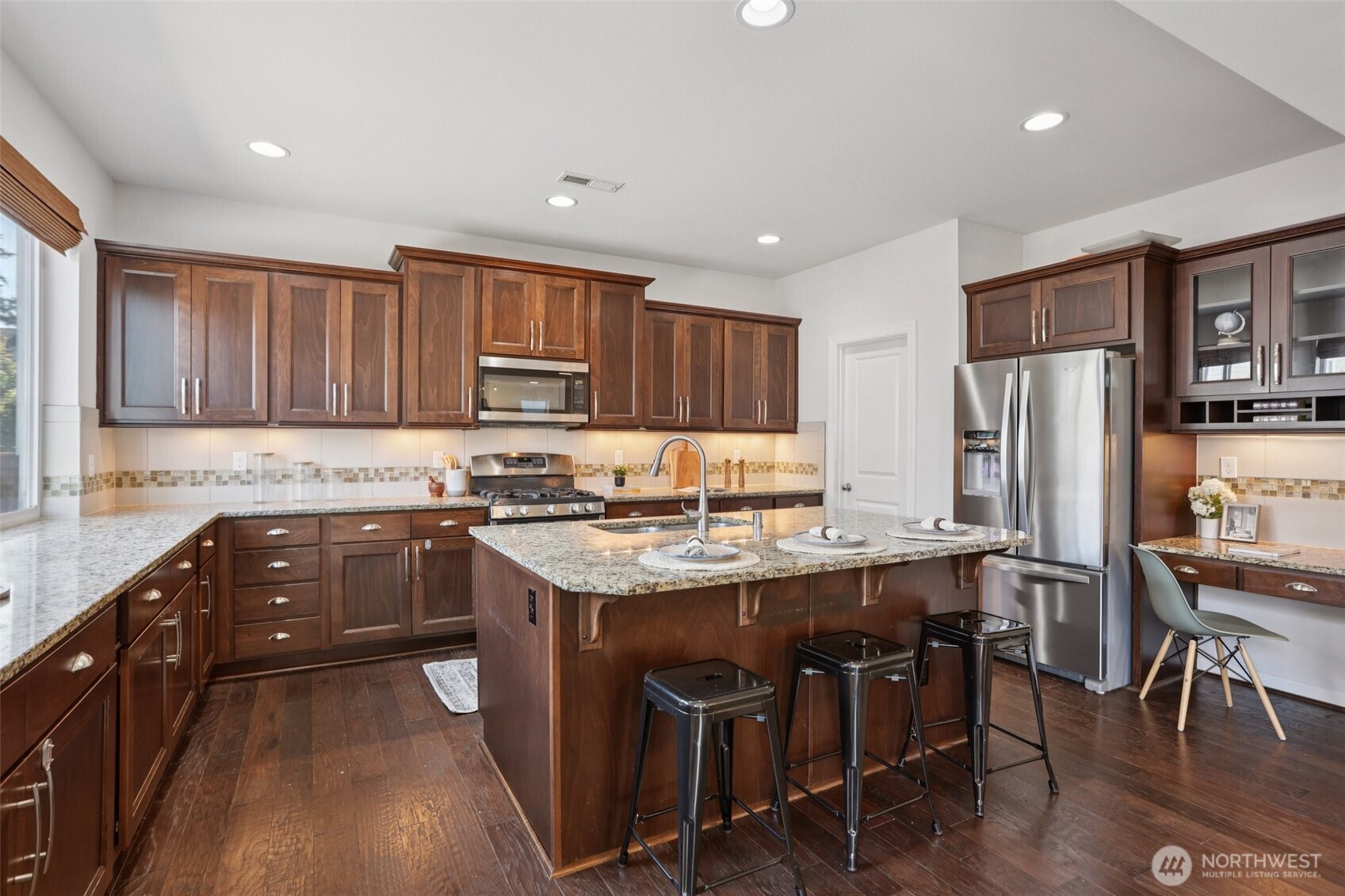 19817 35th Drive Southeast Bothell, WA 98012 - Photo 5 of 34 a kitchen with stainless steel appliances granite countertop a table chairs sink refrigerator and cabinets