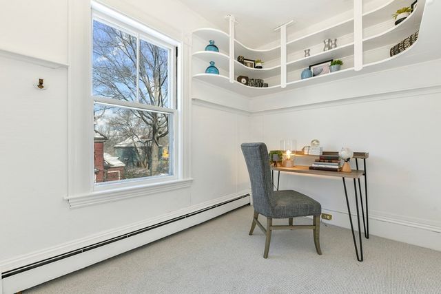 a view of a workspace with furniture and a window