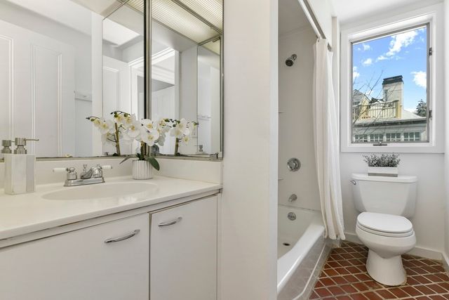 a bathroom with a granite countertop toilet a sink and a mirror