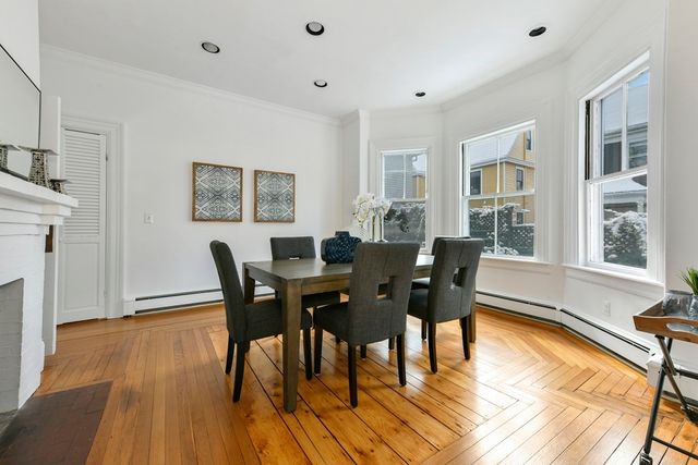 a view of a dining room with furniture a rug and wooden floor
