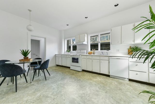 a kitchen with a sink white cabinets and appliances