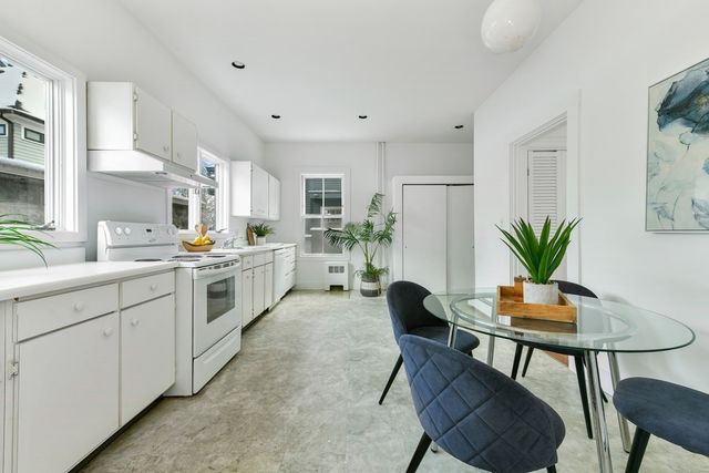 a kitchen with white cabinets and appliances