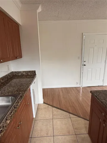 a kitchen with granite countertop a sink and a stove