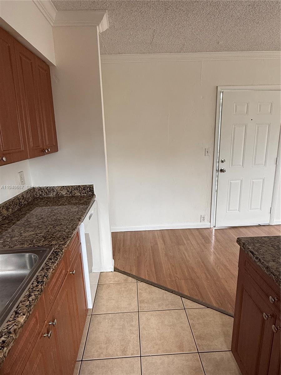 520 Northeast 82nd Terrace, Unit 10 Miami, FL 33138 - Photo 6 of 11 a kitchen with granite countertop a sink and a stove