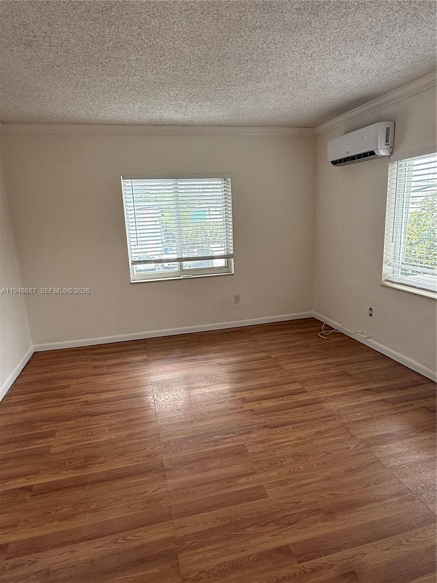 520 Northeast 82nd Terrace, Unit 10 Miami, FL 33138 - Photo 7 of 11 an empty room with wooden floor and windows