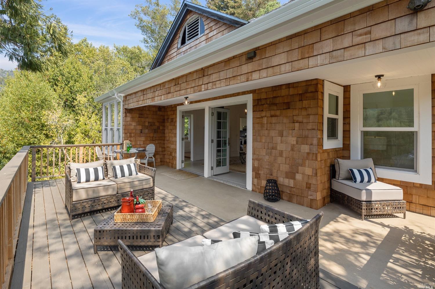 a view of a patio with couches table and chairs and wooden floor
