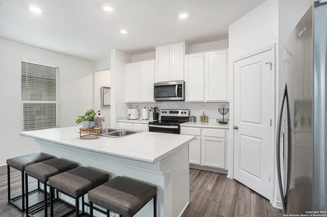 a kitchen with white cabinets and stainless steel appliances