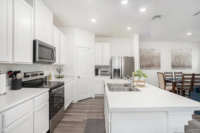 a kitchen with a sink stove and white cabinets