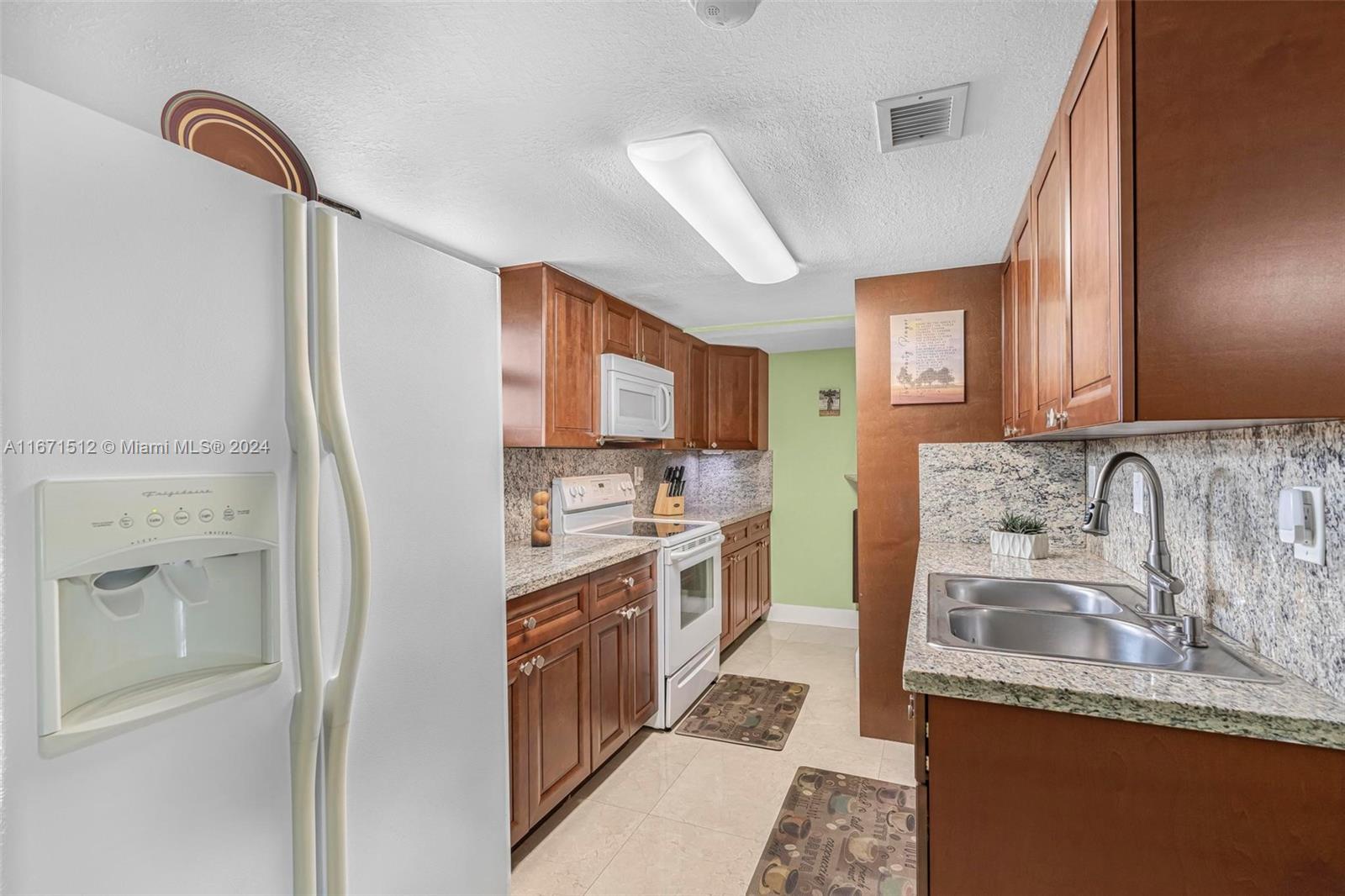 6300 Southwest 138th Court, Unit 307 Miami, FL 33183 - Photo 11 of 30 a kitchen with stainless steel appliances granite countertop a sink stove and refrigerator