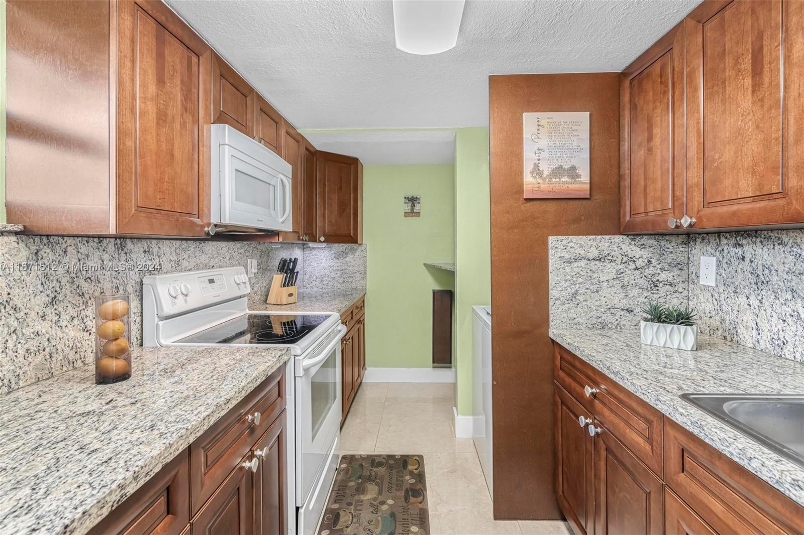 6300 Southwest 138th Court, Unit 307 Miami, FL 33183 - Photo 12 of 30 a kitchen with stainless steel appliances granite countertop a sink stove and cabinets