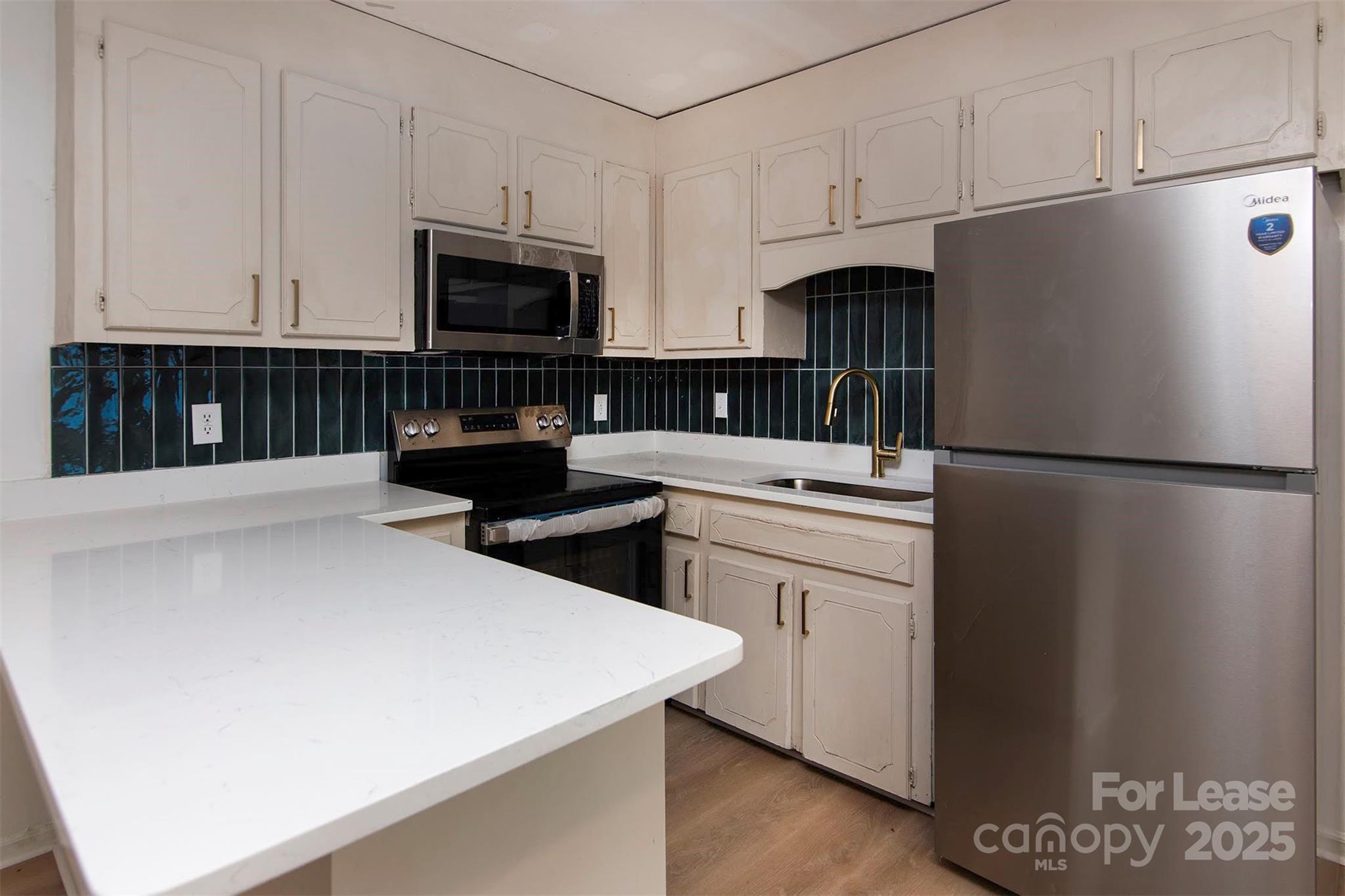 1313 North Main Street, Unit 3 Lowell, NC 28098 - Photo 2 of 10 a kitchen with stainless steel appliances a refrigerator sink and microwave