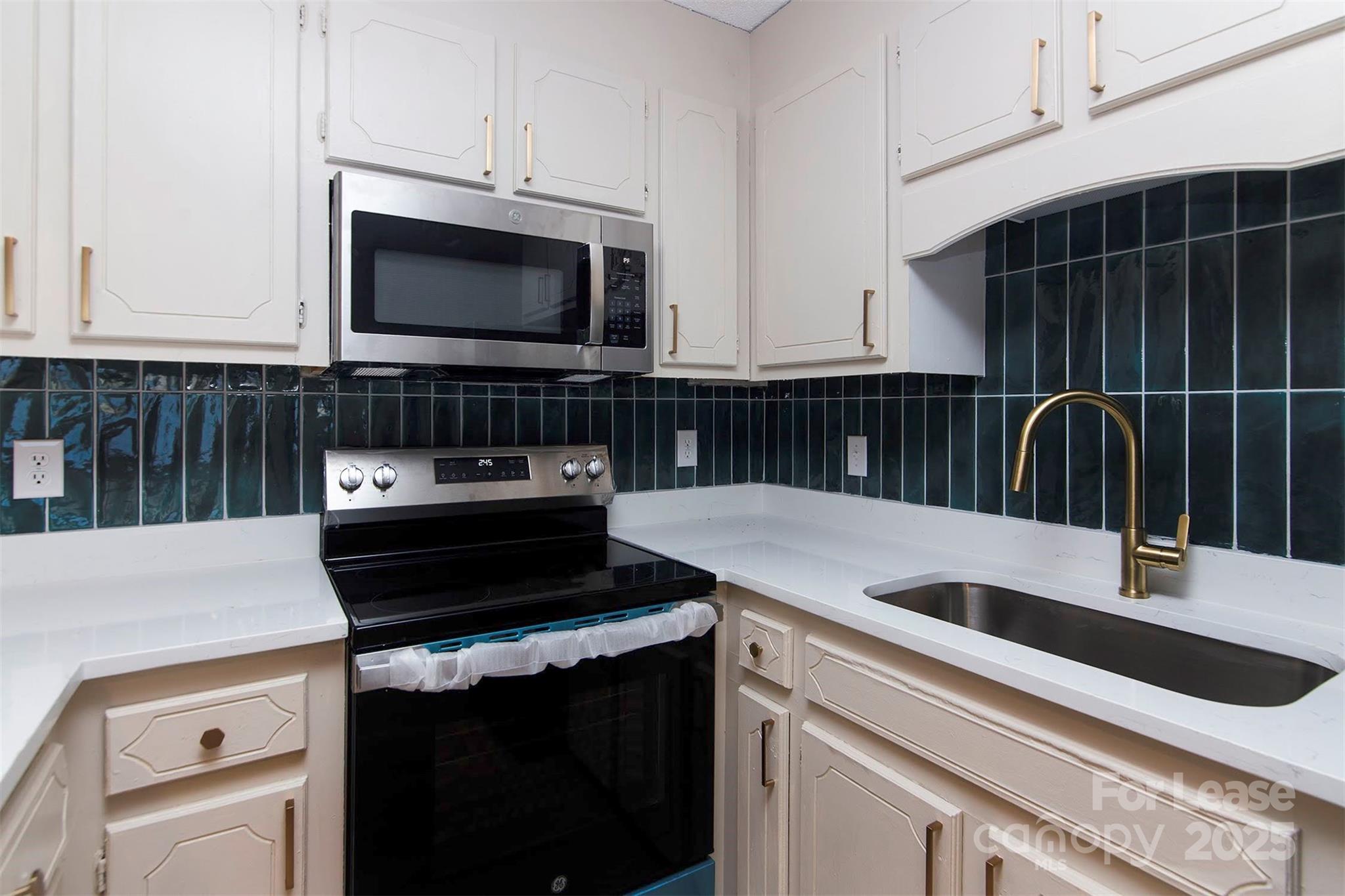 1313 North Main Street, Unit 3 Lowell, NC 28098 - Photo 3 of 10 a kitchen with a sink and a stove top oven with wooden floor