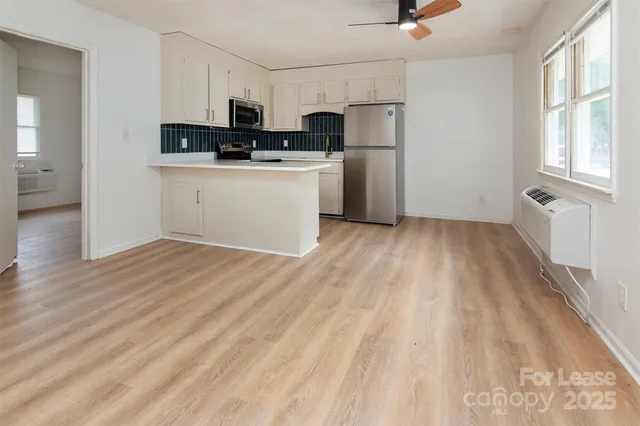 a kitchen with a refrigerator a stove top oven a sink and dishwasher with wooden floor