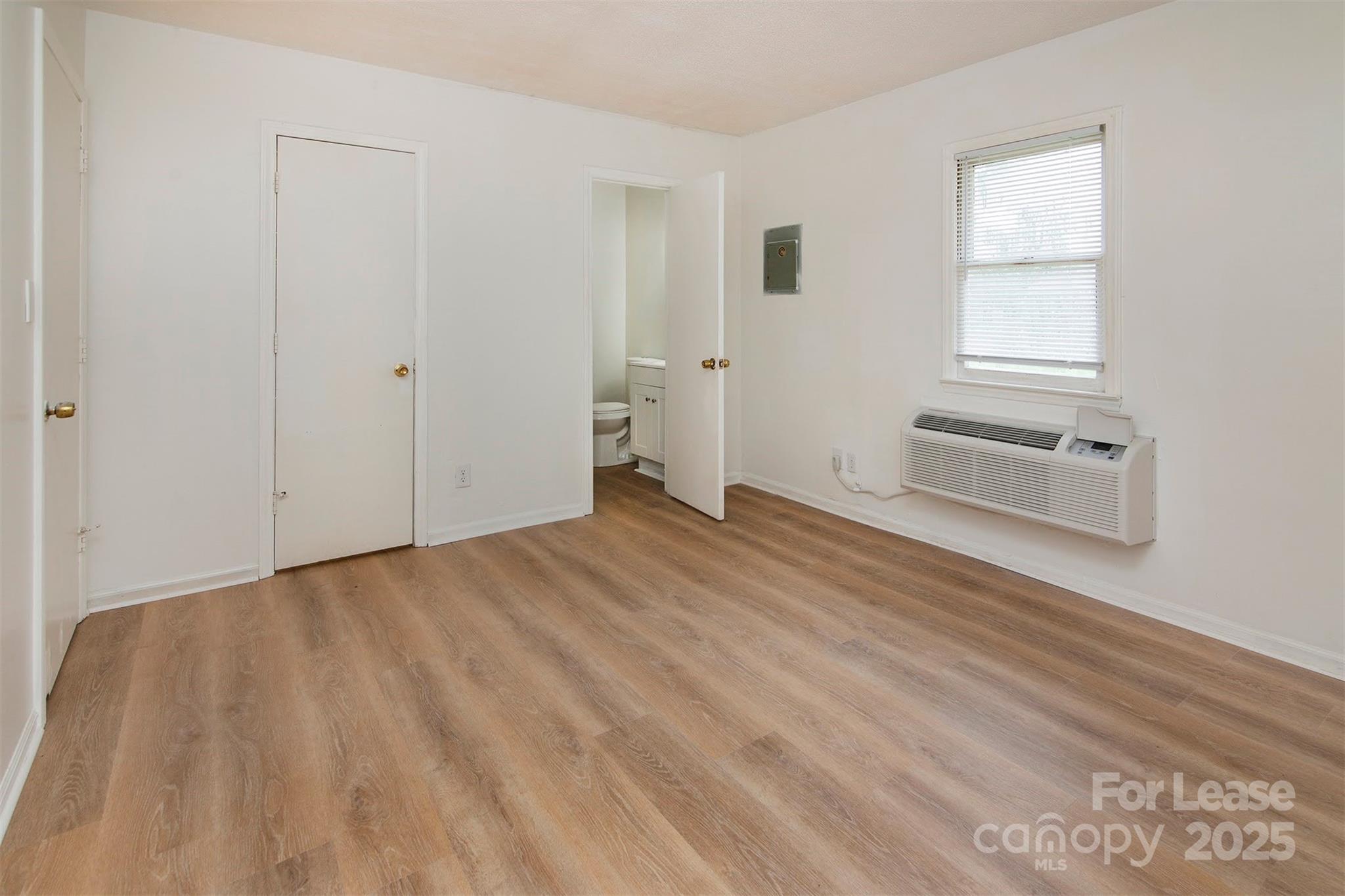 1313 North Main Street, Unit 3 Lowell, NC 28098 - Photo 8 of 10 an empty room with wooden floor and window