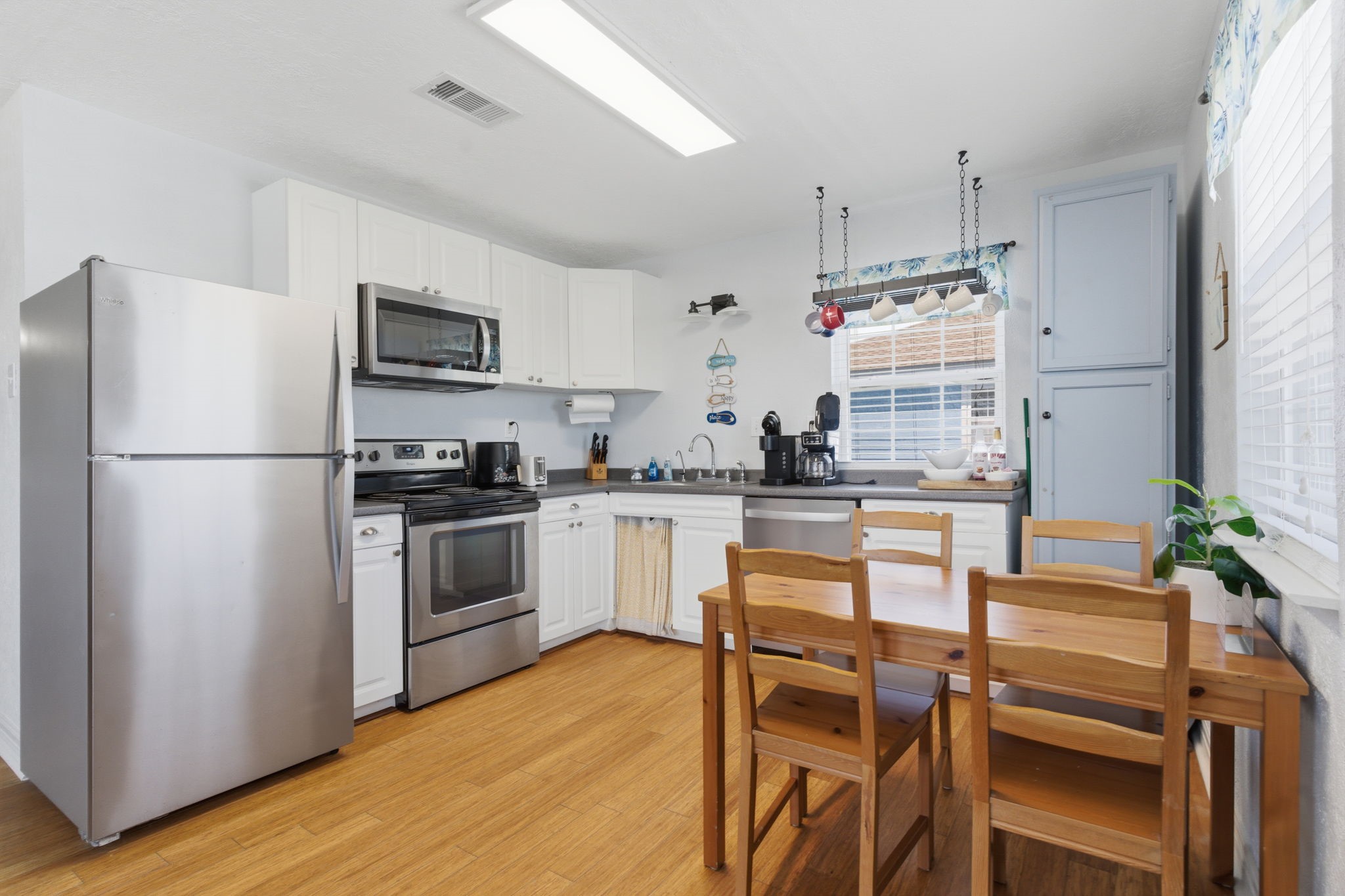 315 Caisson Street Surfside Beach, TX 77541 - Photo 6 of 32 Kitchen – Bright and efficient kitchen featuring white cabinetry, stainless steel appliances, and ample counter space, all enhanced by overhead lighting and a functional layout.