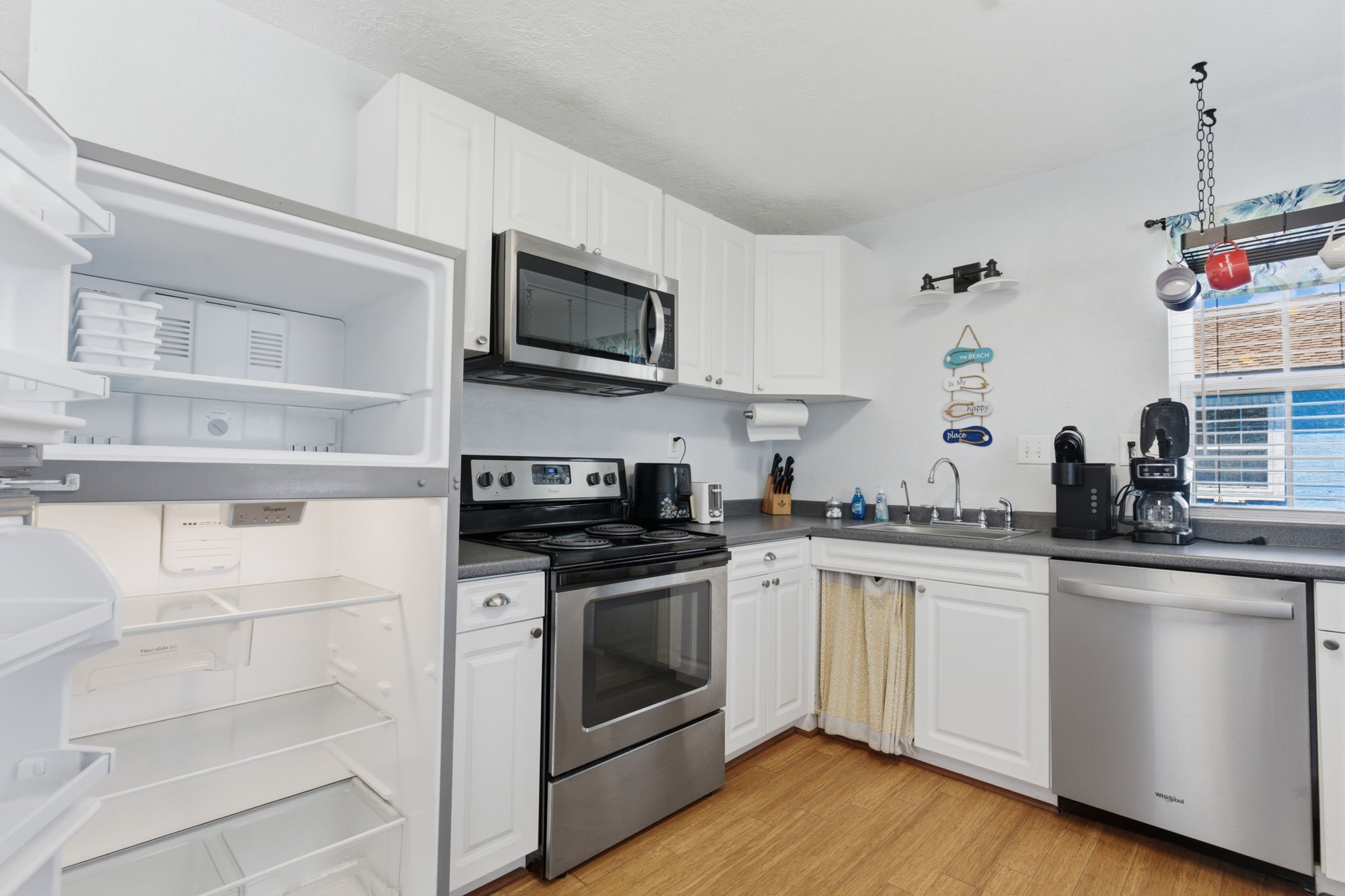 315 Caisson Street Surfside Beach, TX 77541 - Photo 9 of 32 Kitchen (Appliance Detail) – Equipped with modern stainless steel appliances, including range, microwave, and dishwasher, paired with ample cabinetry for organized storage.