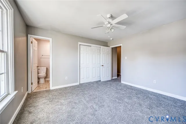 an empty room with closet and fan