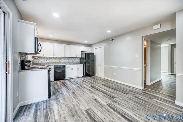 a kitchen with stainless steel appliances granite countertop a refrigerator and a stove top oven