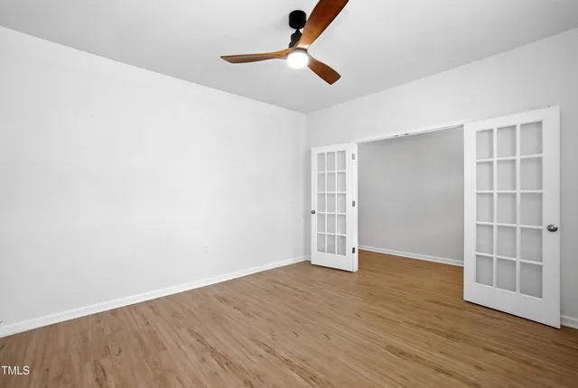 a view of an empty room with wooden floor