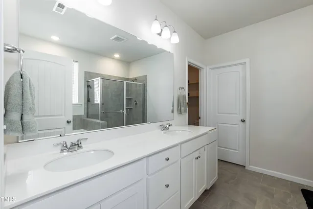 a bathroom with a double vanity sink and a mirror