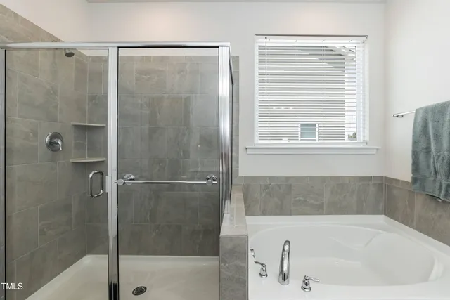 a white bath tub sitting next to a shower