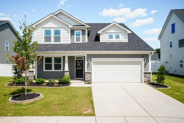 a front view of a house with a yard and garage