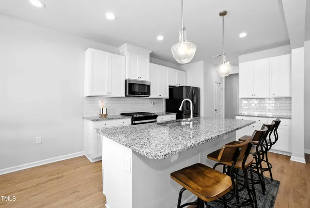 a kitchen with kitchen island granite countertop a sink a center island stainless steel appliances and cabinets