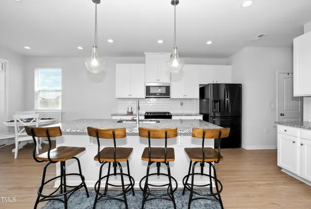 a large kitchen with a table and chairs