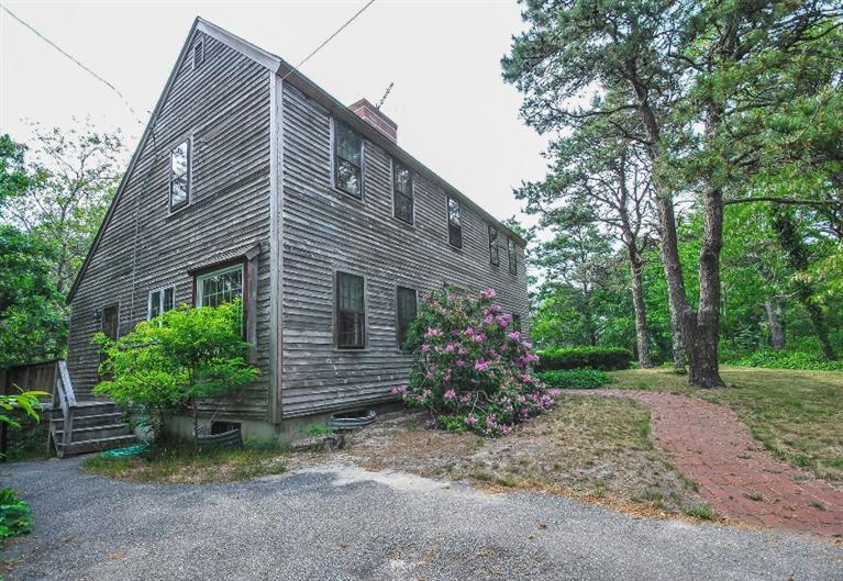 a view of a house with brick walls and a yard with potted plants