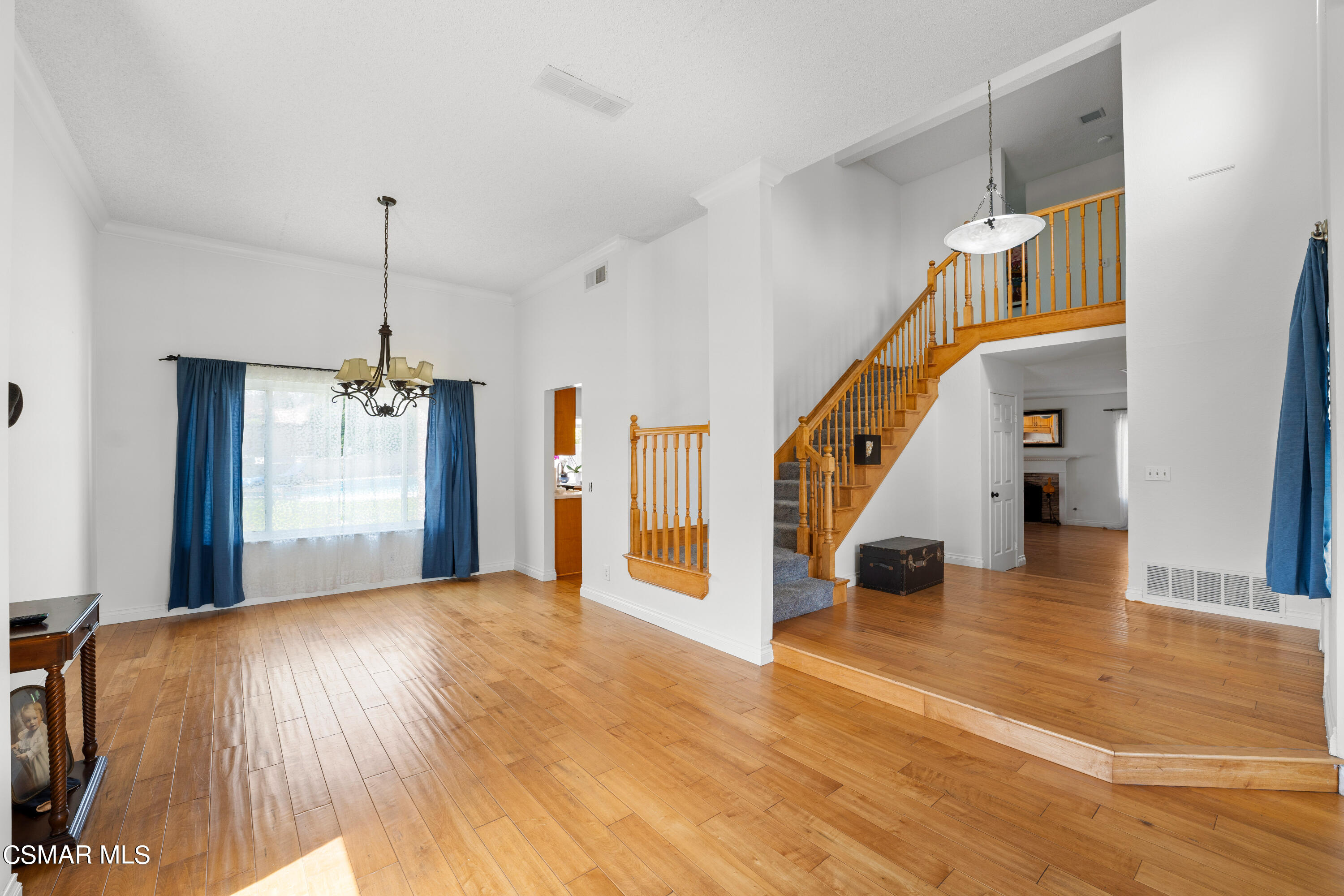 2835 Corte Caballos Camarillo, CA 93010 - Photo 6 of 35 a view of an empty room with wooden floor staircase and a kitchen view