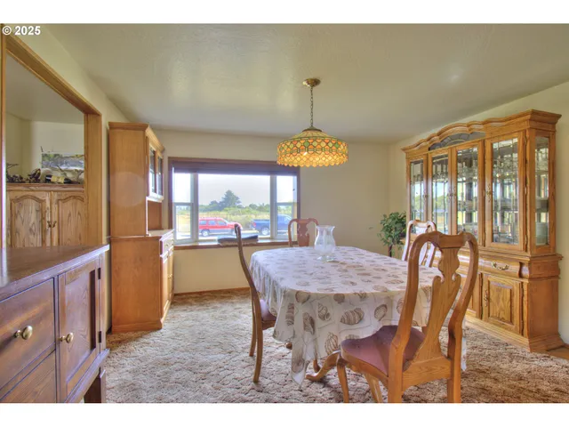 a dining room with furniture a chandelier and wooden floor