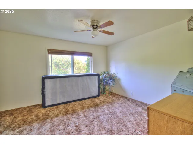 a view of an empty room and kitchen view