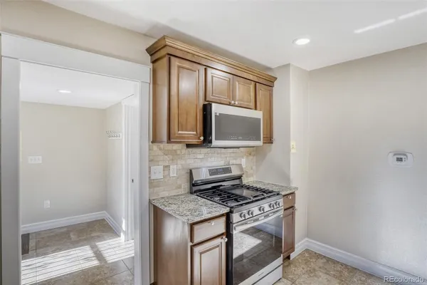 a kitchen with stainless steel appliances granite countertop a stove and a microwave