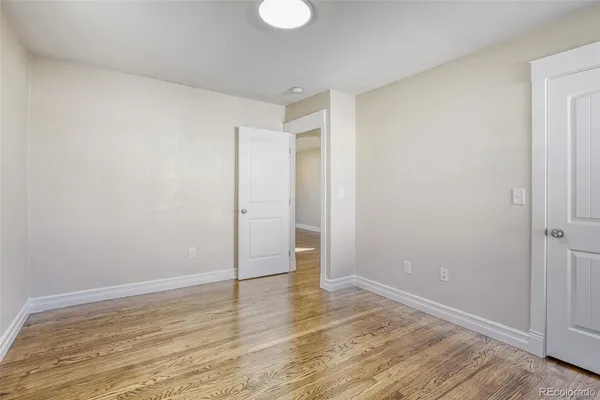 a view of an empty room with wooden floor