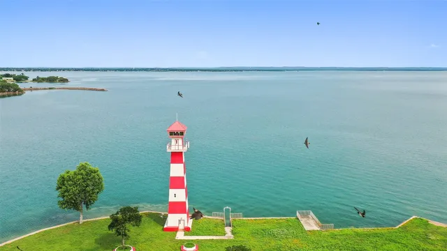 a front view of a house with a yard and lake view