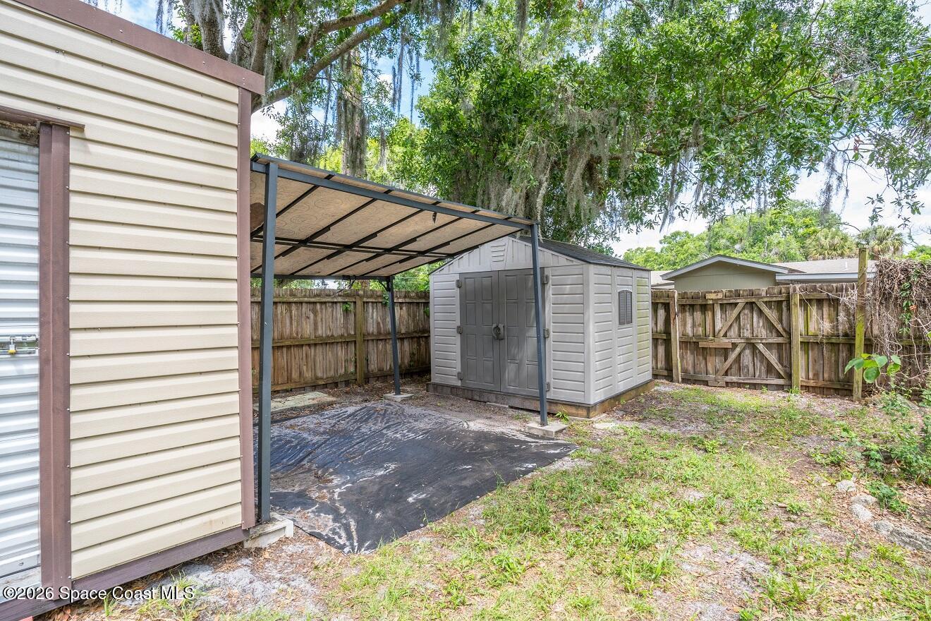 1112 Pinedale Road Rockledge, FL 32955 - Photo 14 of 15 a view of a small house with a small yard and a large tree