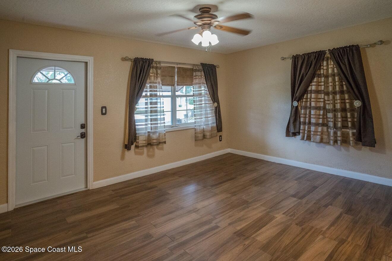 1112 Pinedale Road Rockledge, FL 32955 - Photo 4 of 15 a view of an empty room with wooden floor and a window