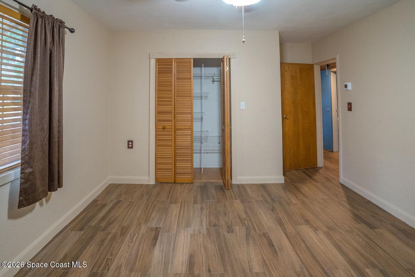 1112 Pinedale Road Rockledge, FL 32955 - Photo 7 of 15 an empty room with wooden floor and closet